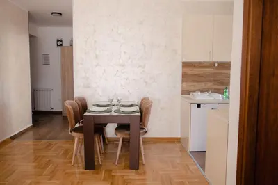 a dining room with a wooden table and chairs at Lux 010 in Pirot