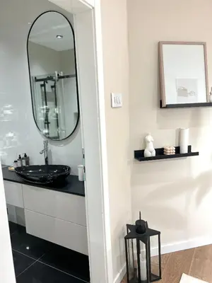 a bathroom with a black sink and a mirror at Japandi Home in Niš