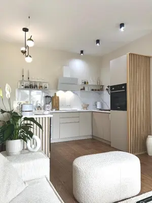 a kitchen with white cabinets and a white chair at Japandi Home in Niš