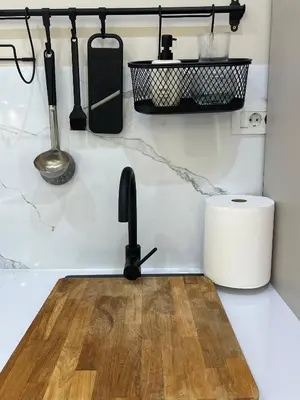 a kitchen counter with a wooden cutting board and utensils at Japandi Home in Niš