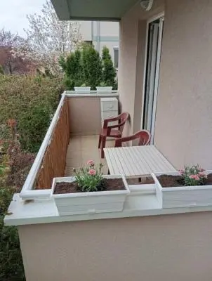 a balcony with a bench and a table and flowers at Banjski Raj in Vrnjačka Banja
