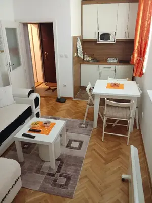 a small living room with a table and a kitchen at Banjski Raj in Vrnjačka Banja