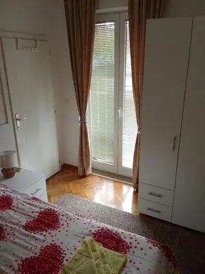 a bedroom with a bed and a large window at Banjski Raj in Vrnjačka Banja