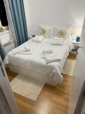 a white bed with towels on it in a room at Apartman Vuk in Vrnjačka Banja