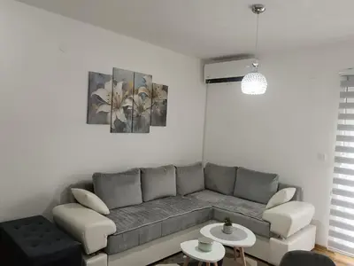 a living room with a gray couch and a table at Apartman Sofija in Vrnjačka Banja