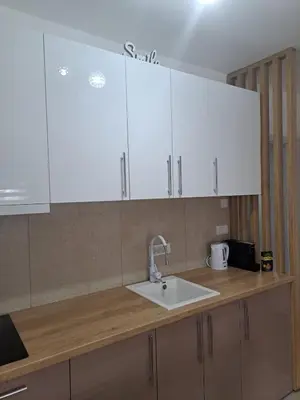 a kitchen counter with white cabinets and a sink at Apartman Sofija in Vrnjačka Banja
