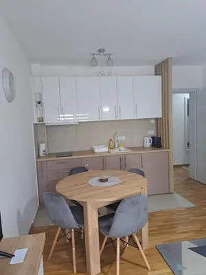 a kitchen with a wooden table and chairs at Apartman Sofija in Vrnjačka Banja