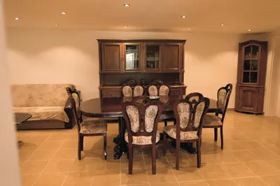 a dining room with a table and chairs and a couch at Villa Perla in Despotovac
