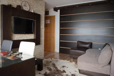 a living room with a couch and a tv at Apartment 204 in Kopaonik