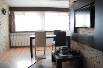 a living room with a table and two chairs at Apartment 204 in Kopaonik