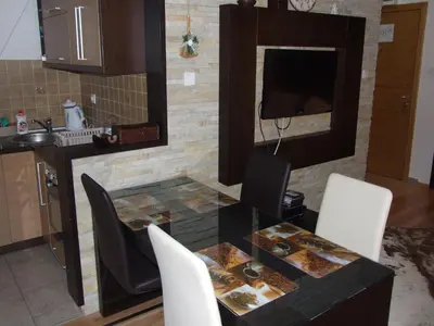 a kitchen with a table and chairs with food on it at Apartment 204 in Kopaonik