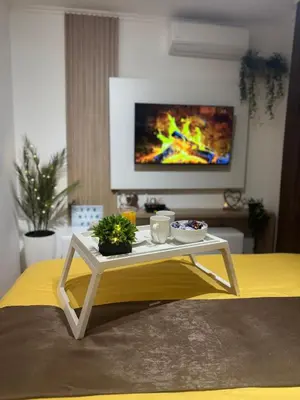 a coffee table in a living room with a tv at SpaNish apartman 4 in Niš