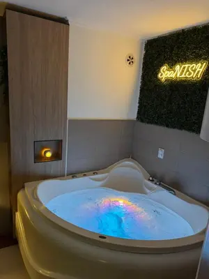 a jacuzzi tub in a room with a sign at SpaNish apartman 4 in Niš
