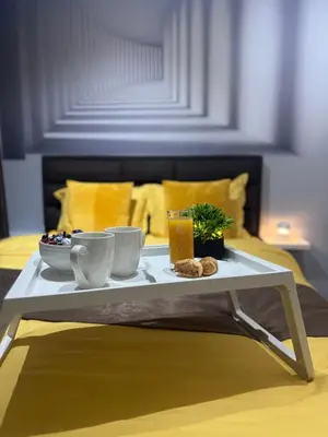 a coffee table with a tray of food on a bed at SpaNish apartman 4 in Niš