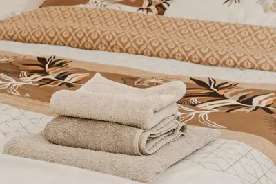 a pile of towels sitting on top of two beds at Apartman ELEVEN in Kraljevo