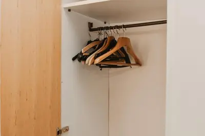 a closet with a bunch of wooden hangers at Apartman ELEVEN in Kraljevo