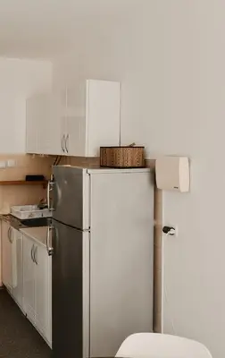 a kitchen with a refrigerator and a basket on top of it at Apartman ELEVEN in Kraljevo