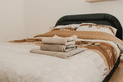 a bed with towels sitting on top of it at Apartman ELEVEN in Kraljevo