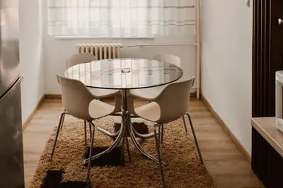 a dining room with a glass table and chairs at Apartman ELEVEN in Kraljevo