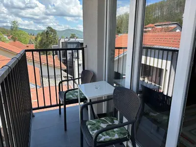 a balcony with two chairs and a table on a balcony at Apartman Mirka, Vrnjačka Banja in Vrnjačka Banja