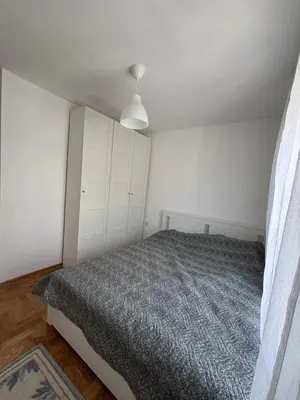 a bedroom with a bed and a white cabinet at Apartman Mirka, Vrnjačka Banja in Vrnjačka Banja