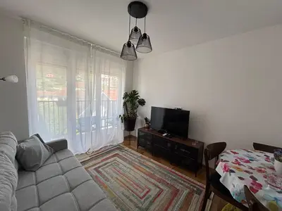 a living room with a couch and a flat screen tv at Apartman Mirka, Vrnjačka Banja in Vrnjačka Banja