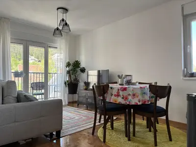 a living room with a table with chairs and a couch at Apartman Mirka, Vrnjačka Banja in Vrnjačka Banja