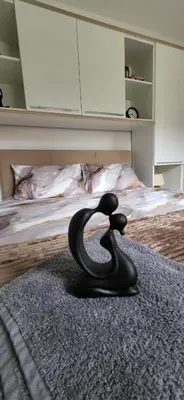 a black animal statue sitting on top of a bed at Apartman Kety Sokobanja in Soko Banja