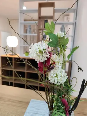 a vase filled with white and red flowers on a table at Bili Prestige Lux in Paraćin