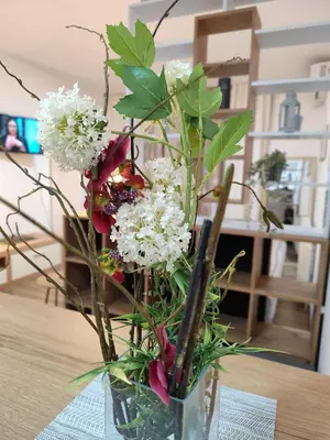 a vase with flowers in it on a table at Bili Prestige Lux in Paraćin