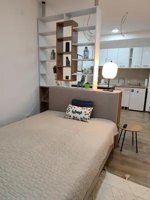 a bedroom with a bed and a room with a kitchen at Bili Prestige Lux in Paraćin