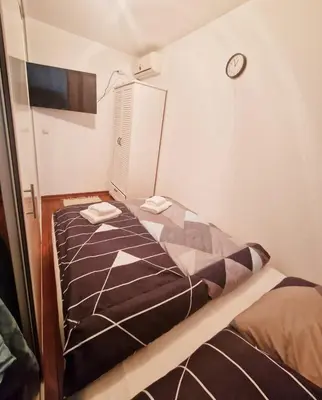 a bedroom with a bed and a clock on the wall at See U in Pegaz in Vrnjačka Banja
