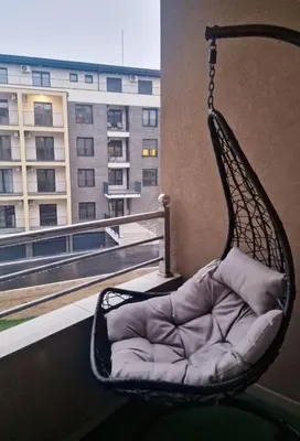 a swing chair on a balcony with a building at See U in Pegaz in Vrnjačka Banja