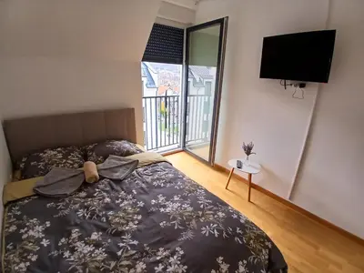 a bedroom with a bed and a flat screen tv at Apartman TRIP in Soko Banja