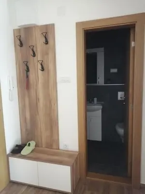 a bathroom with a shower with scissors on the wall at Apartman TRIP in Soko Banja
