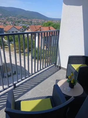 a balcony with two chairs and a table with a view at Apartman TRIP in Soko Banja
