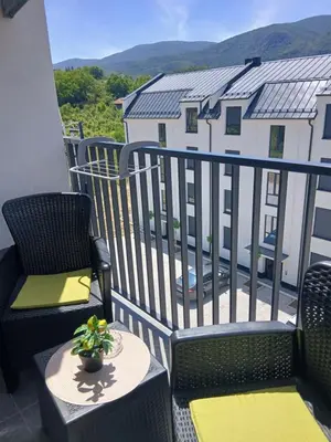 a balcony with two chairs and a table with a plant at Apartman TRIP in Soko Banja