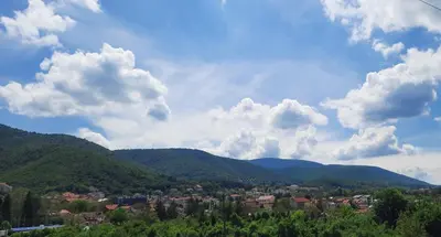 a town in the mountains under a cloudy sky at Apartman TRIP in Soko Banja