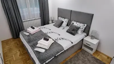 a bedroom with a large bed with towels on it at Apartman TiHana in Pirot