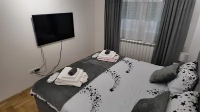 a bedroom with a bed with a flat screen tv at Apartman TiHana in Pirot