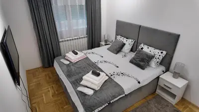 a bedroom with a large bed with towels on it at Apartman TiHana in Pirot
