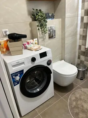 a washing machine in a bathroom with a toilet at Apartman TiHana in Pirot