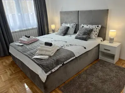 a bedroom with a large bed with towels on it at Apartman TiHana in Pirot