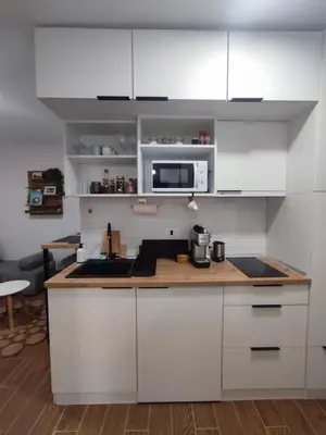 a kitchen with white cabinets and a counter top at Zvuk Treske in Kopaonik