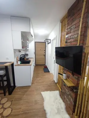 a living room with a flat screen tv on a brick wall at Zvuk Treske in Kopaonik