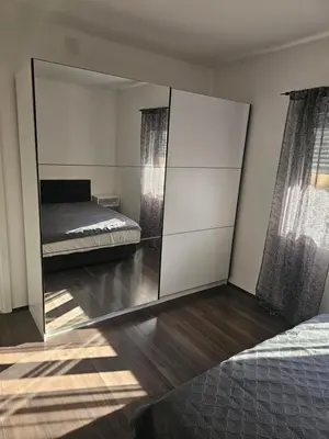 a bedroom with a mirror and a bed in it at Ivys apartman in Ćuprija