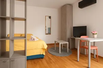 a bedroom with a bed and a desk with a computer at Rose casa apartments Vrnjacka Banja in Vrnjci