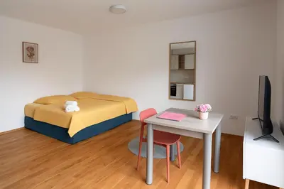 a small room with a bed and a table with a table at Rose casa apartments Vrnjacka Banja in Vrnjci