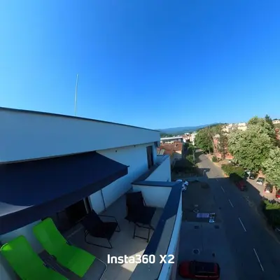 a balcony of a building with chairs and a street at Rose casa apartments Vrnjacka Banja in Vrnjci