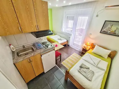 a small kitchen with a sink and a bed at Vila Aleksandra 1 Sokobanja in Soko Banja